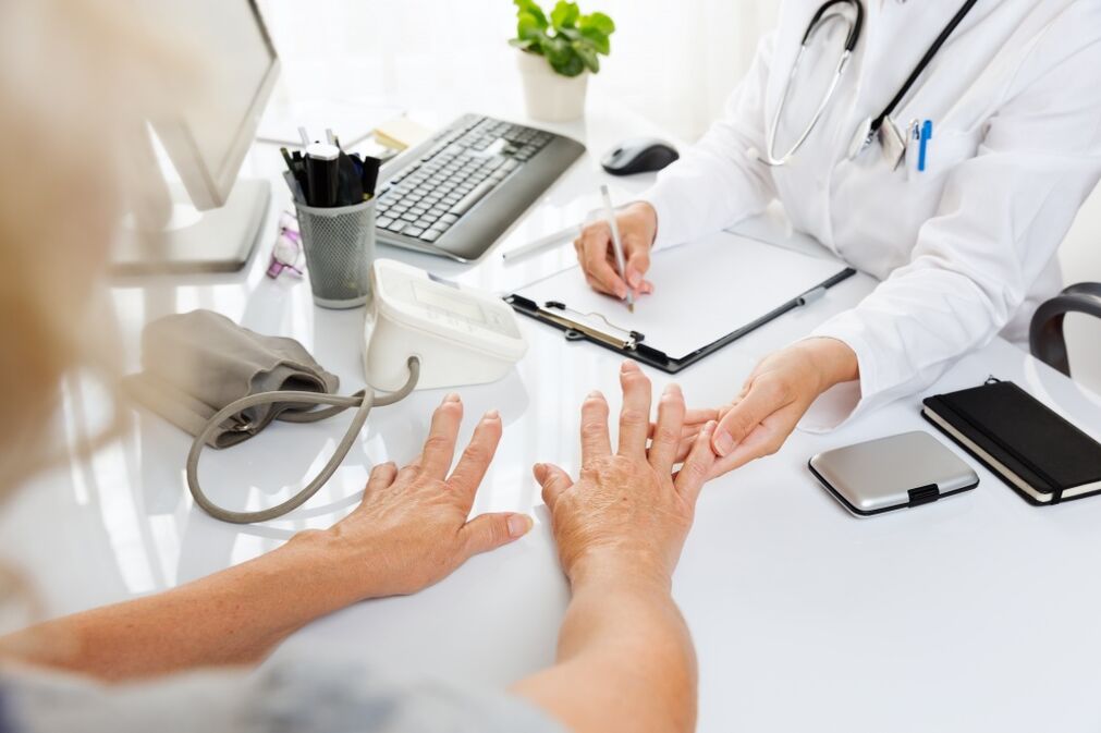 doctor examines hands with arthrosis